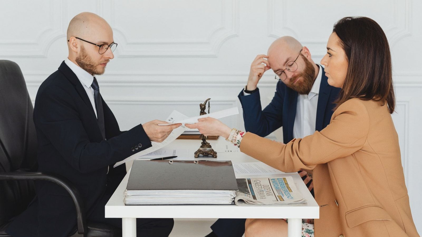 Professional meeting with lawyer and clients discussing documents in a modern office.
