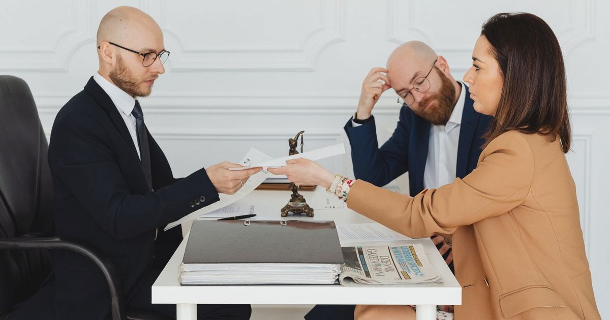 Professional meeting with lawyer and clients discussing documents in a modern office.