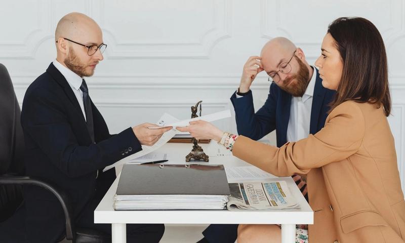Professional meeting with lawyer and clients discussing documents in a modern office.