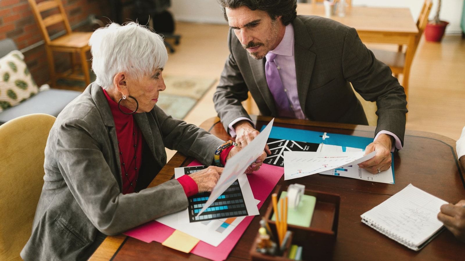 Senior colleagues engaged in a business meeting discussing documents at the office.