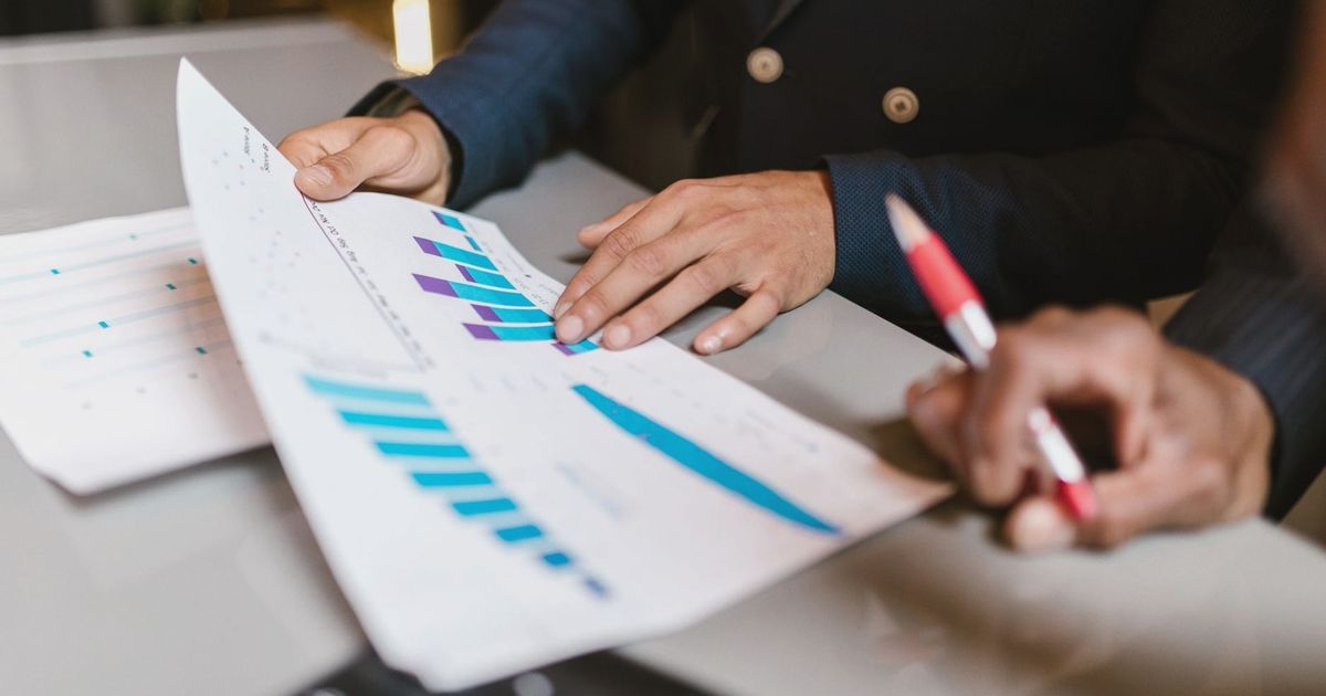 Close-up of professionals reviewing financial graphs at a business meeting.