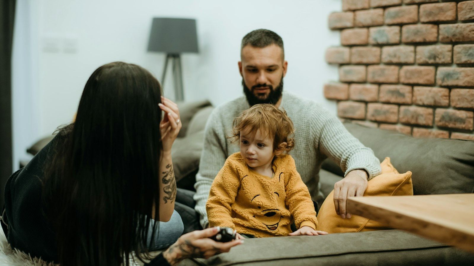 a man sitting on a couch next to a little girl