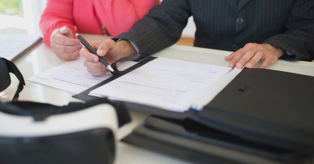 Close-up of professionals signing a business contract indoors, emphasizing agreement and documentation.