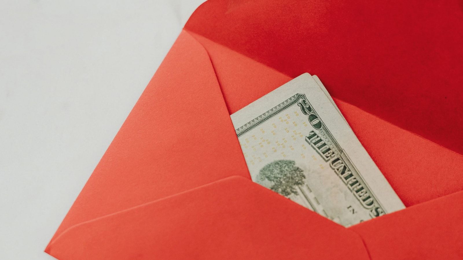 A red envelope containing U.S. dollar bills, symbolizing wealth and gifting.