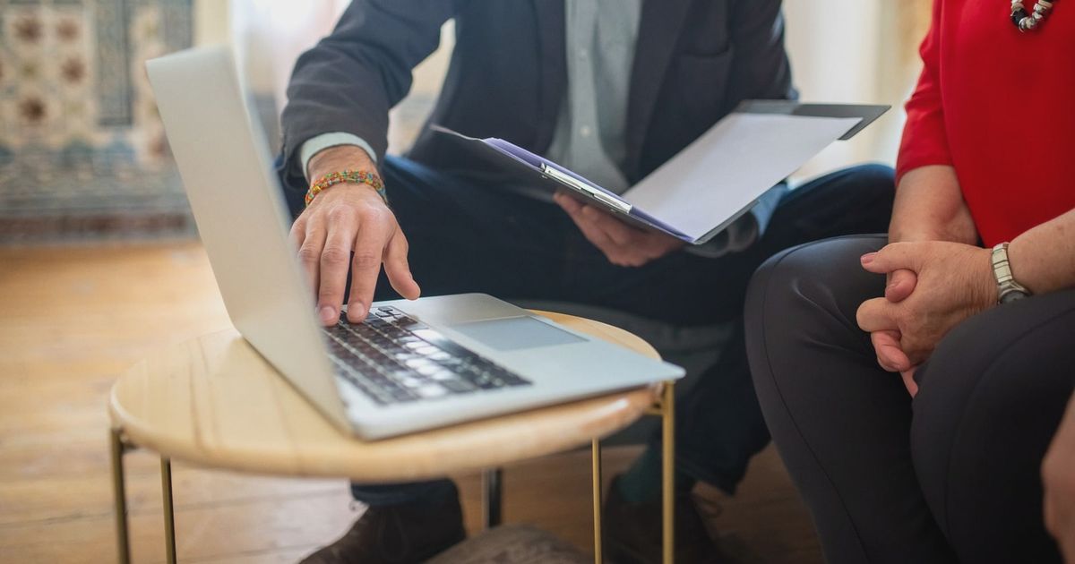 Professional meeting with a laptop and documents in an office setting.