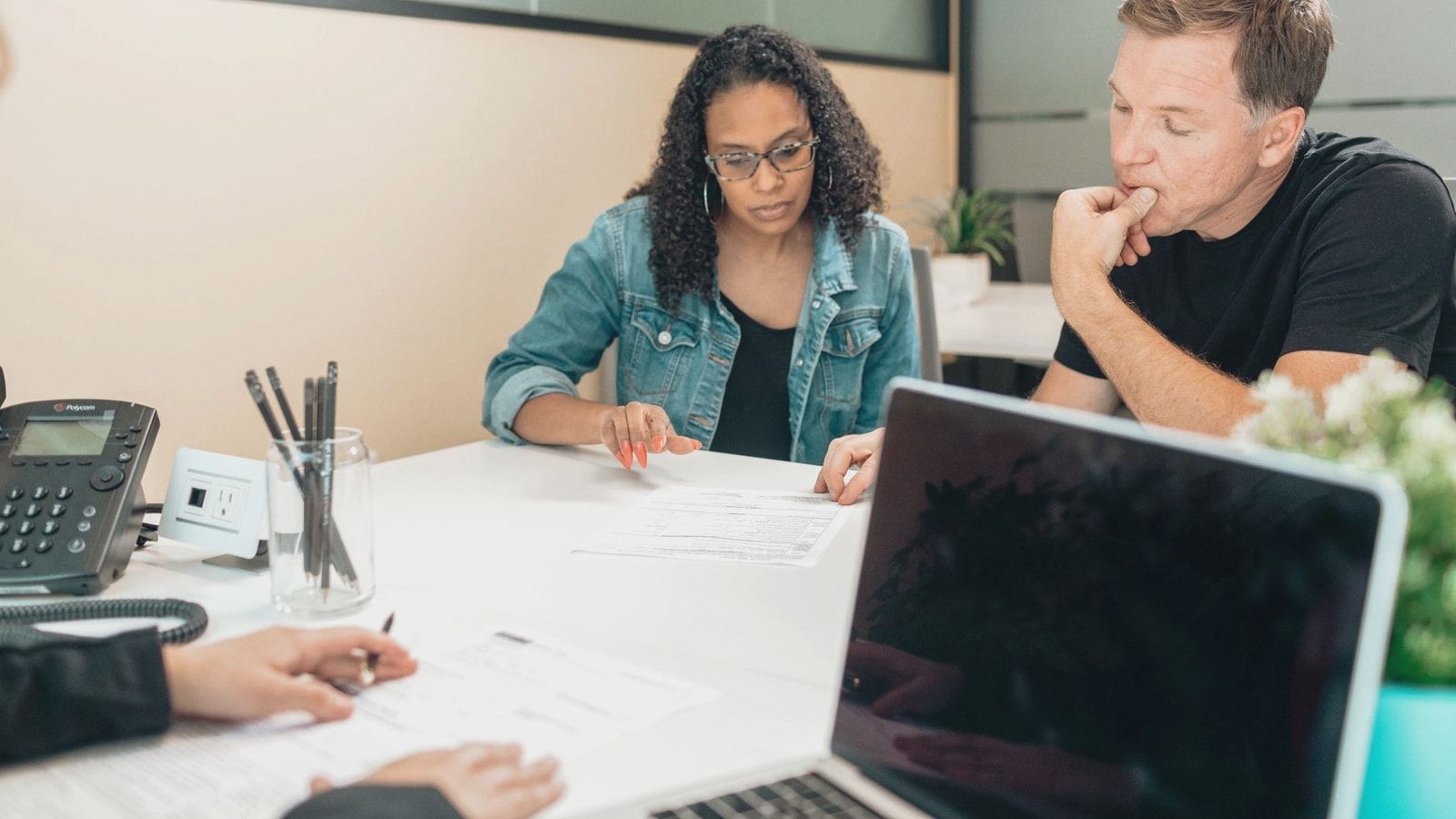 A couple discussing legal documents inside an office setting with an advisor.