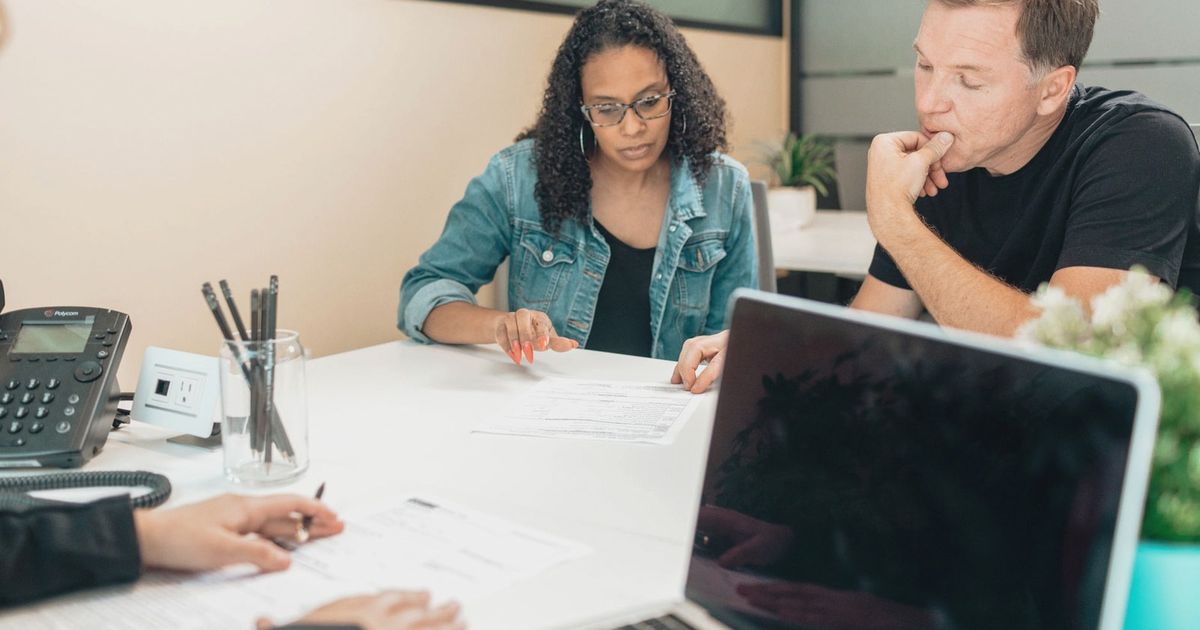 A couple discussing legal documents inside an office setting with an advisor.
