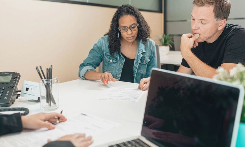 A couple discussing legal documents inside an office setting with an advisor.