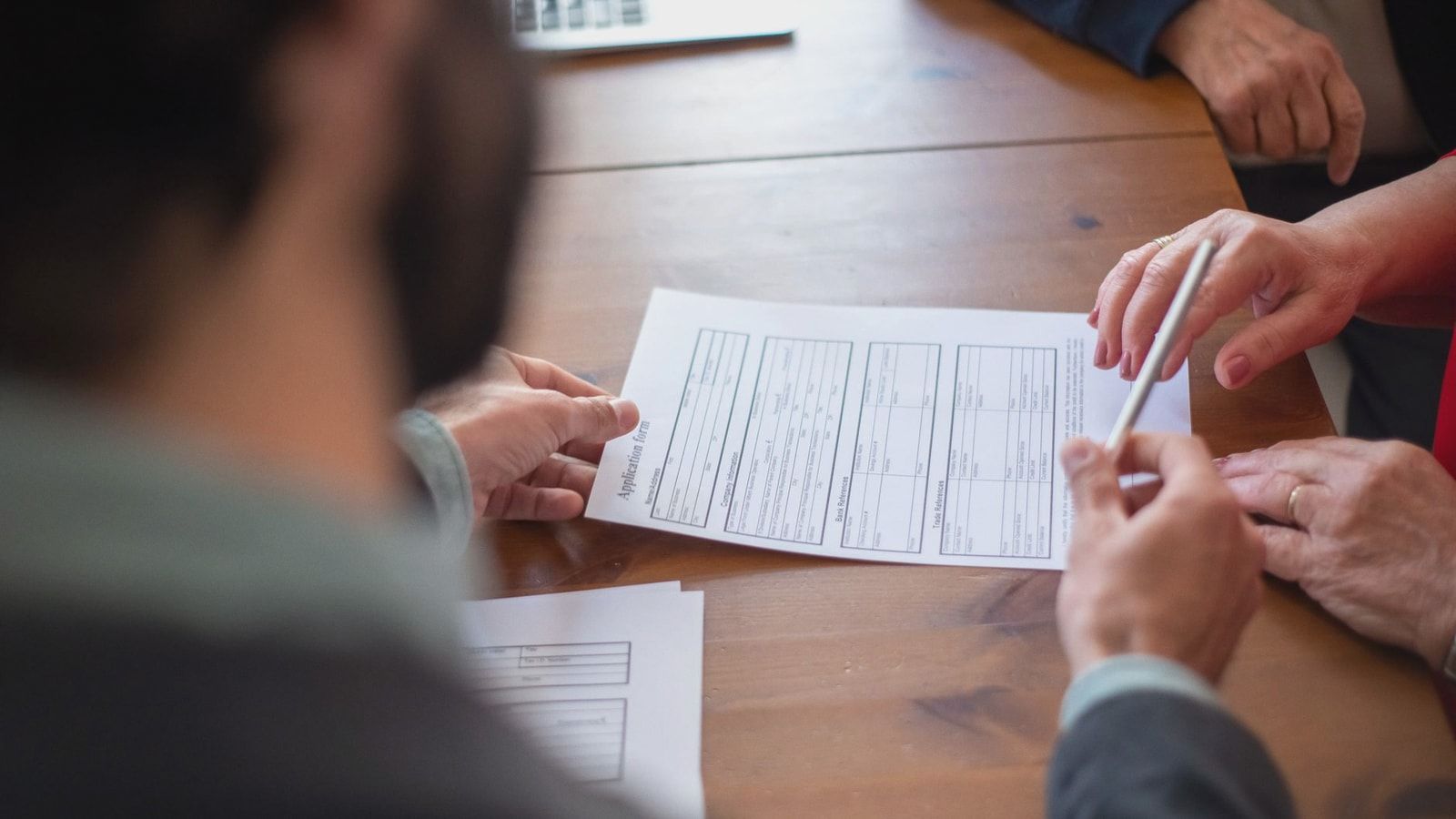 Close-up of business professionals reviewing documents at a meeting.