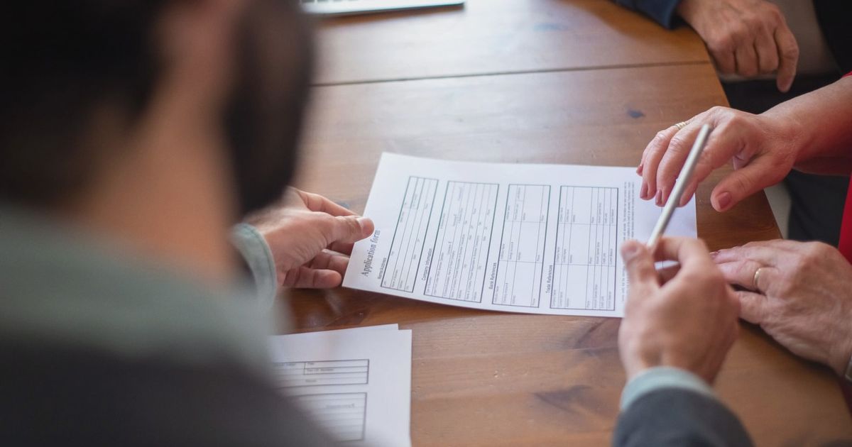 Close-up of business professionals reviewing documents at a meeting.