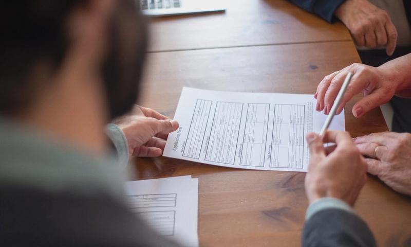 Close-up of business professionals reviewing documents at a meeting.