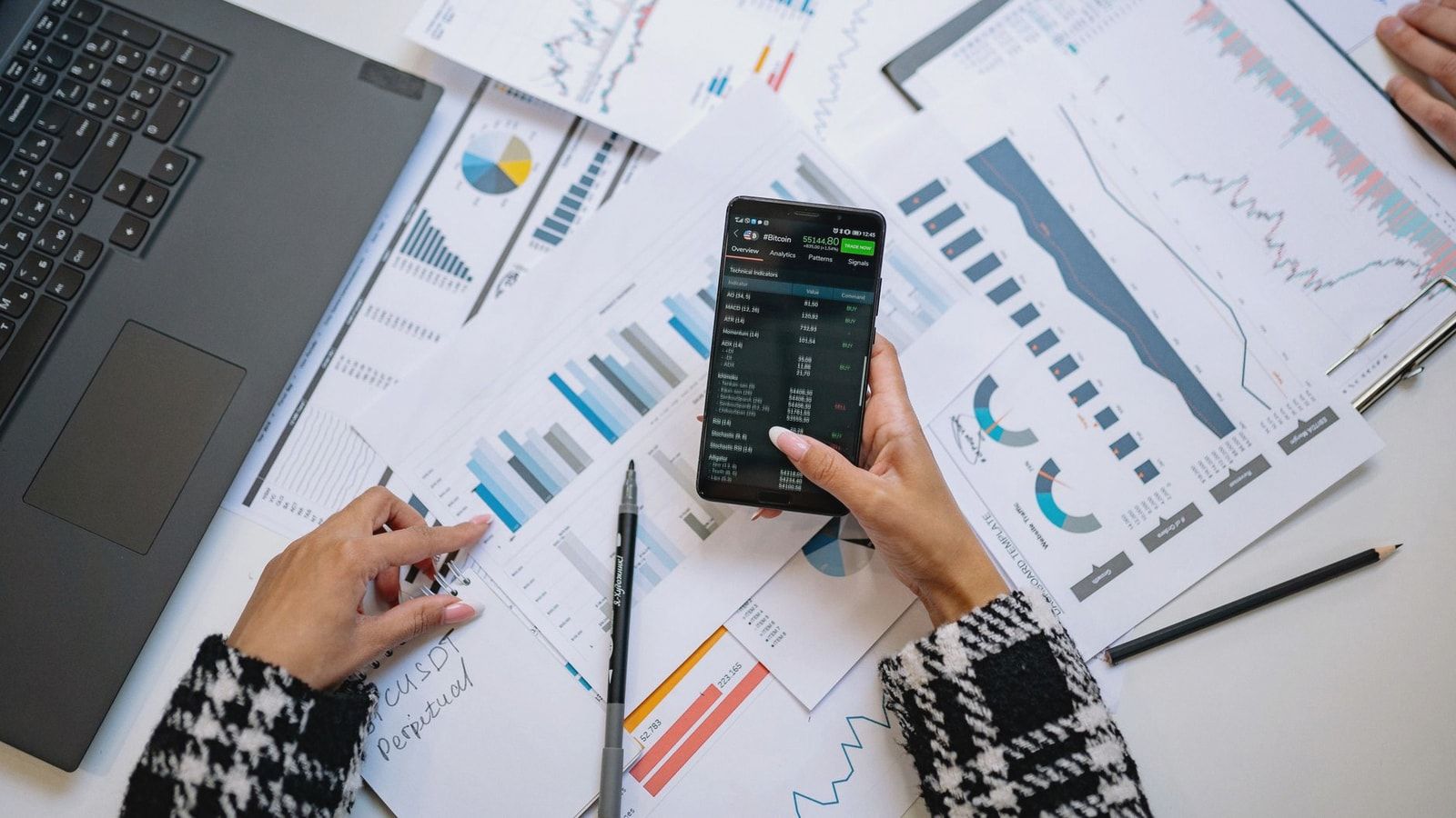 A top view on charts and smartphone in an office, showcasing data analytics.
