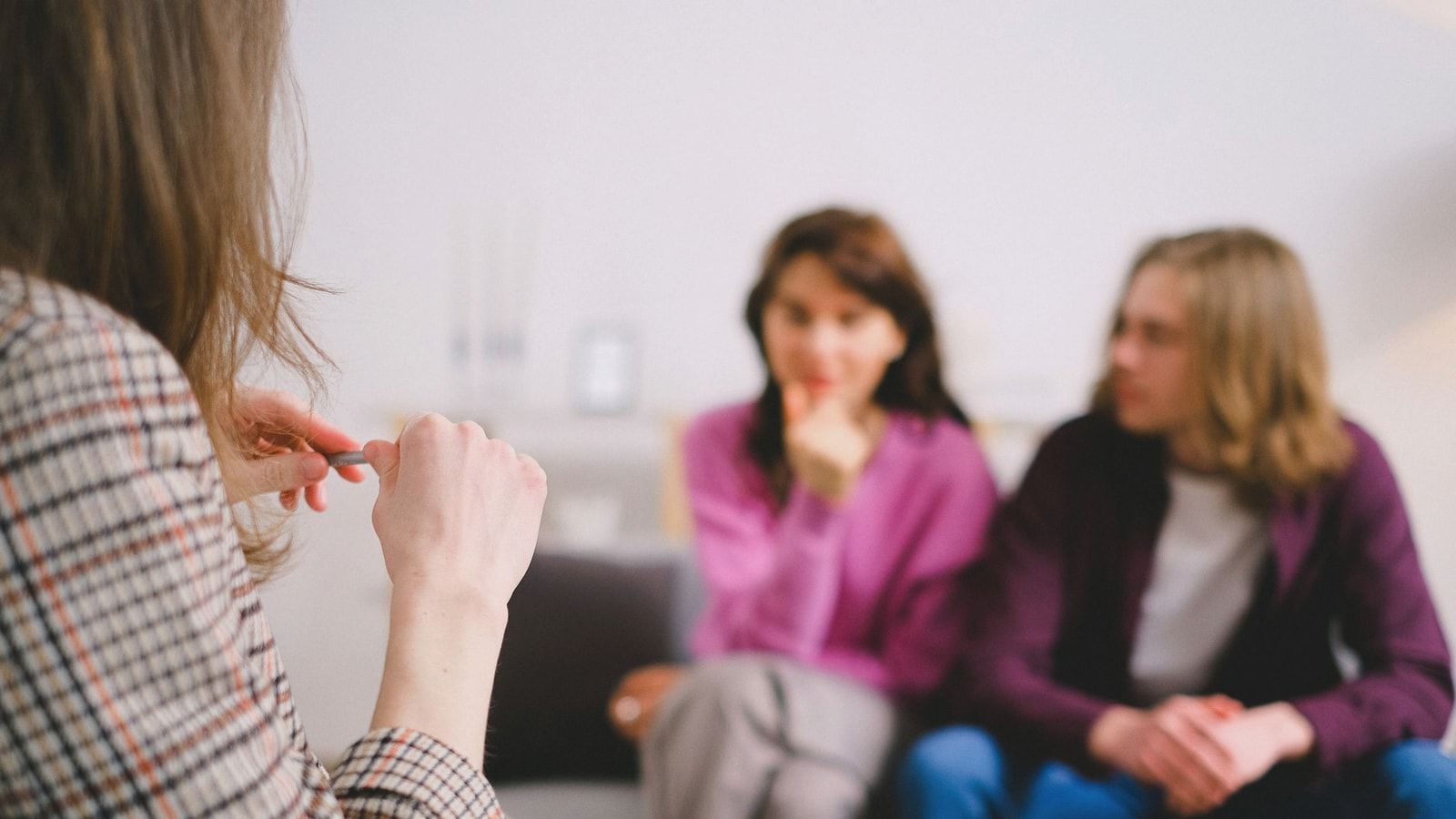 A couple in therapy, guided by a professional therapist in a calm setting.