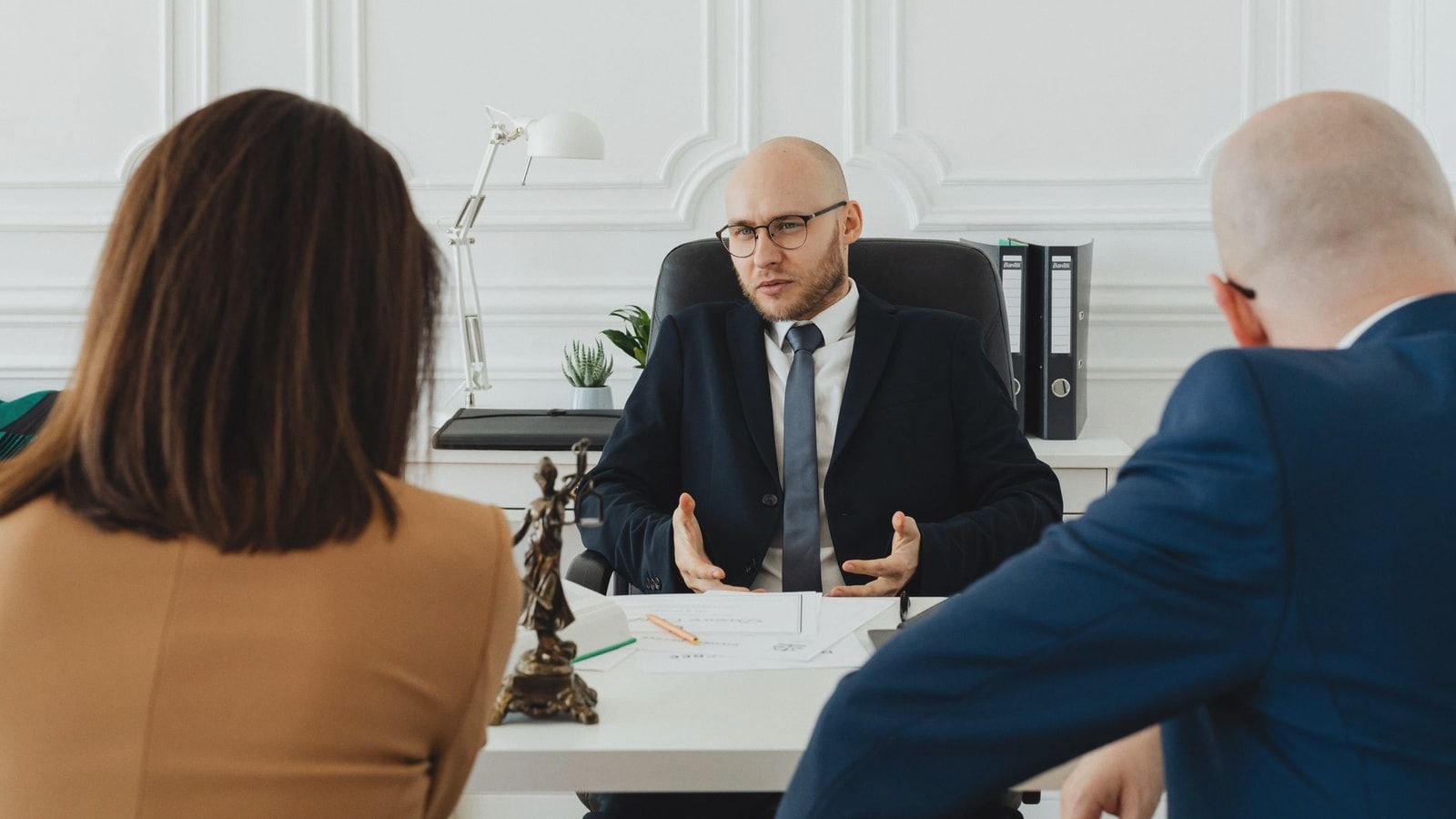 A professional business meeting with a lawyer and clients in a modern office setting.
