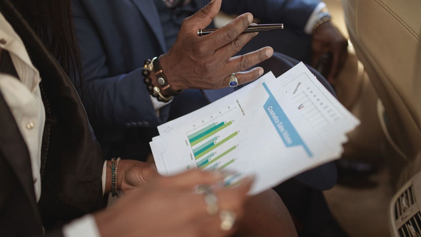 Close-up of business professionals discussing financial documents in a meeting.