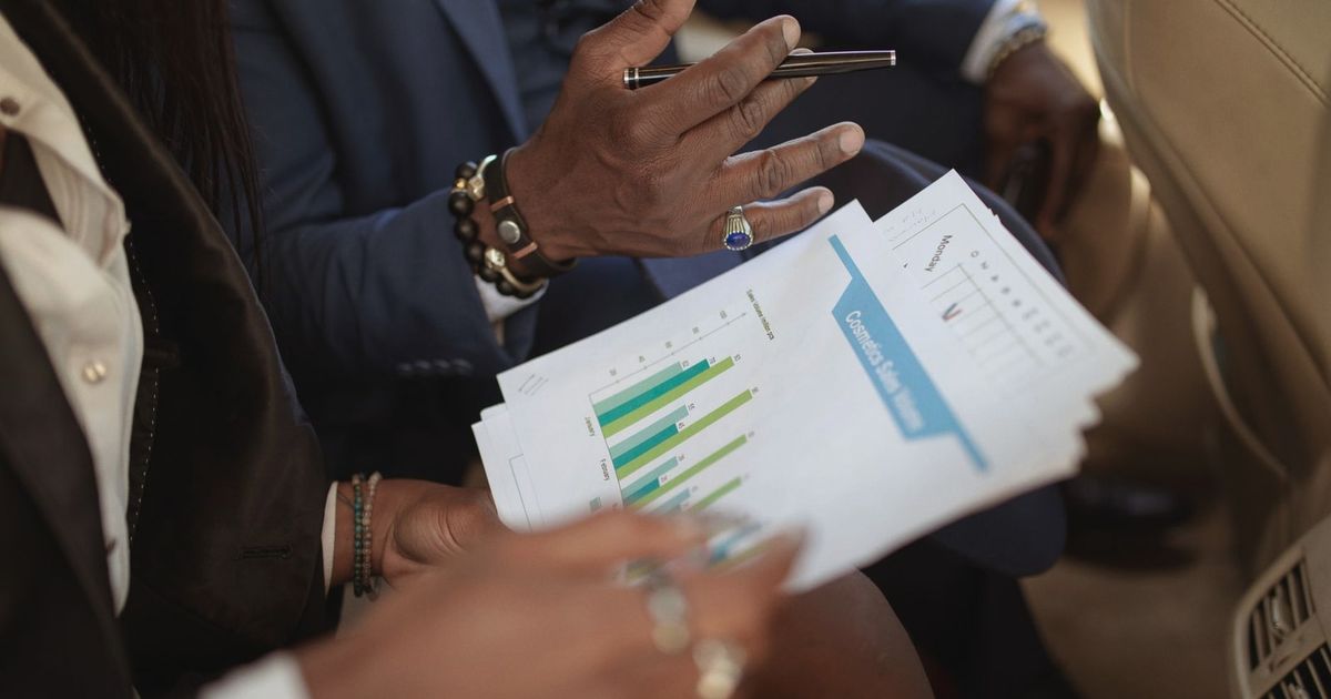 Close-up of business professionals discussing financial documents in a meeting.
