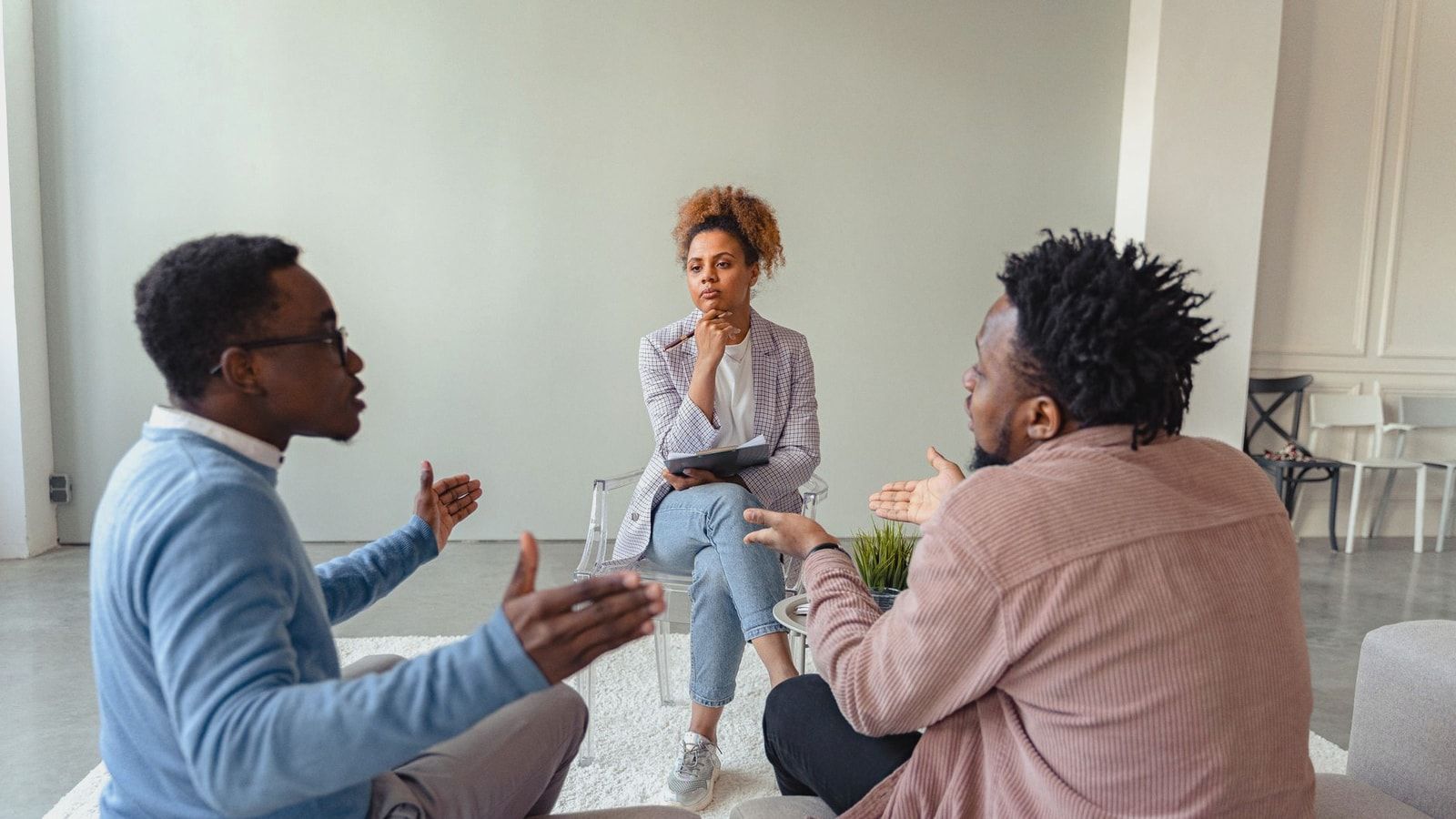 A therapy session featuring a diverse group discussing issues with a mental health professional.
