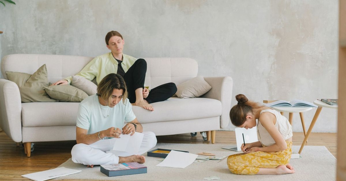 A family enjoying quality time with art and relaxation in a cozy living room setting.