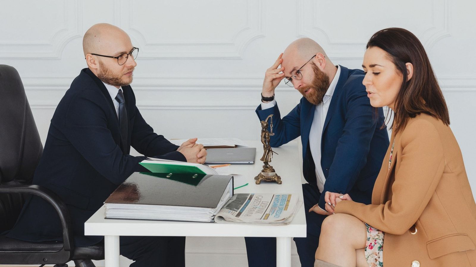 Lawyer consulting couple on divorce settlement in an office setting.