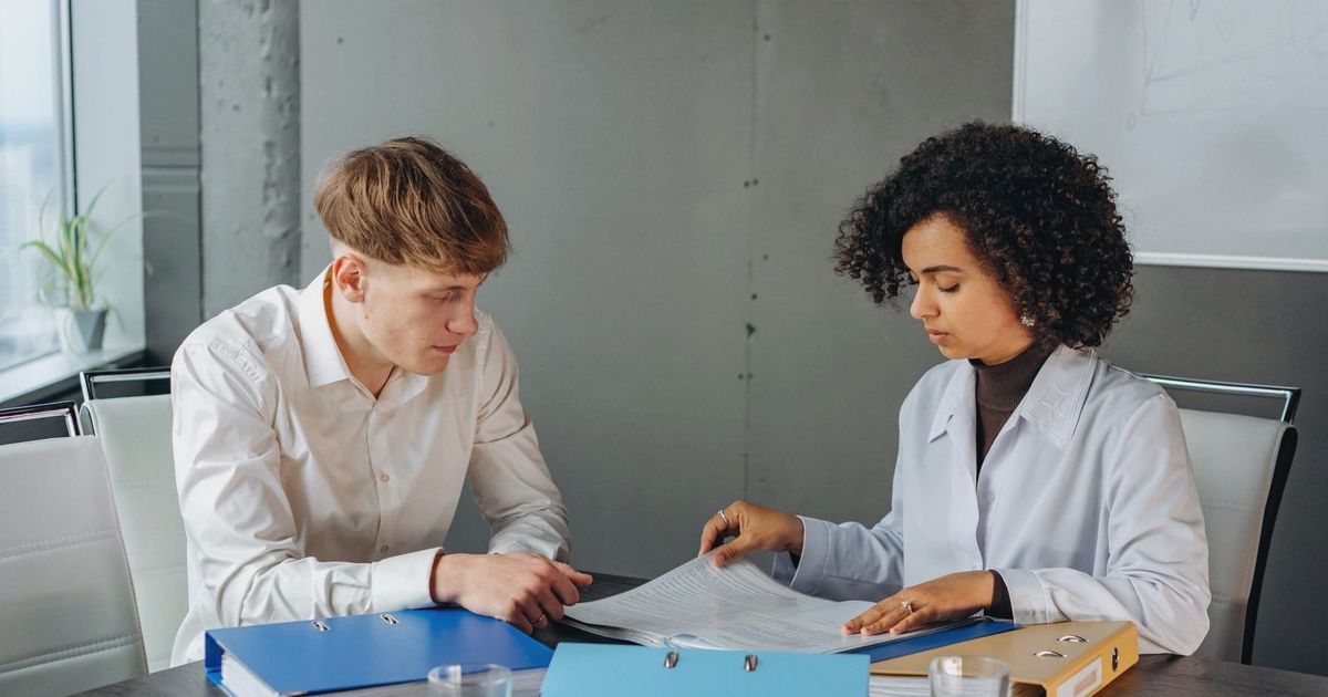 Two colleagues discussing important business documents at an office desk.