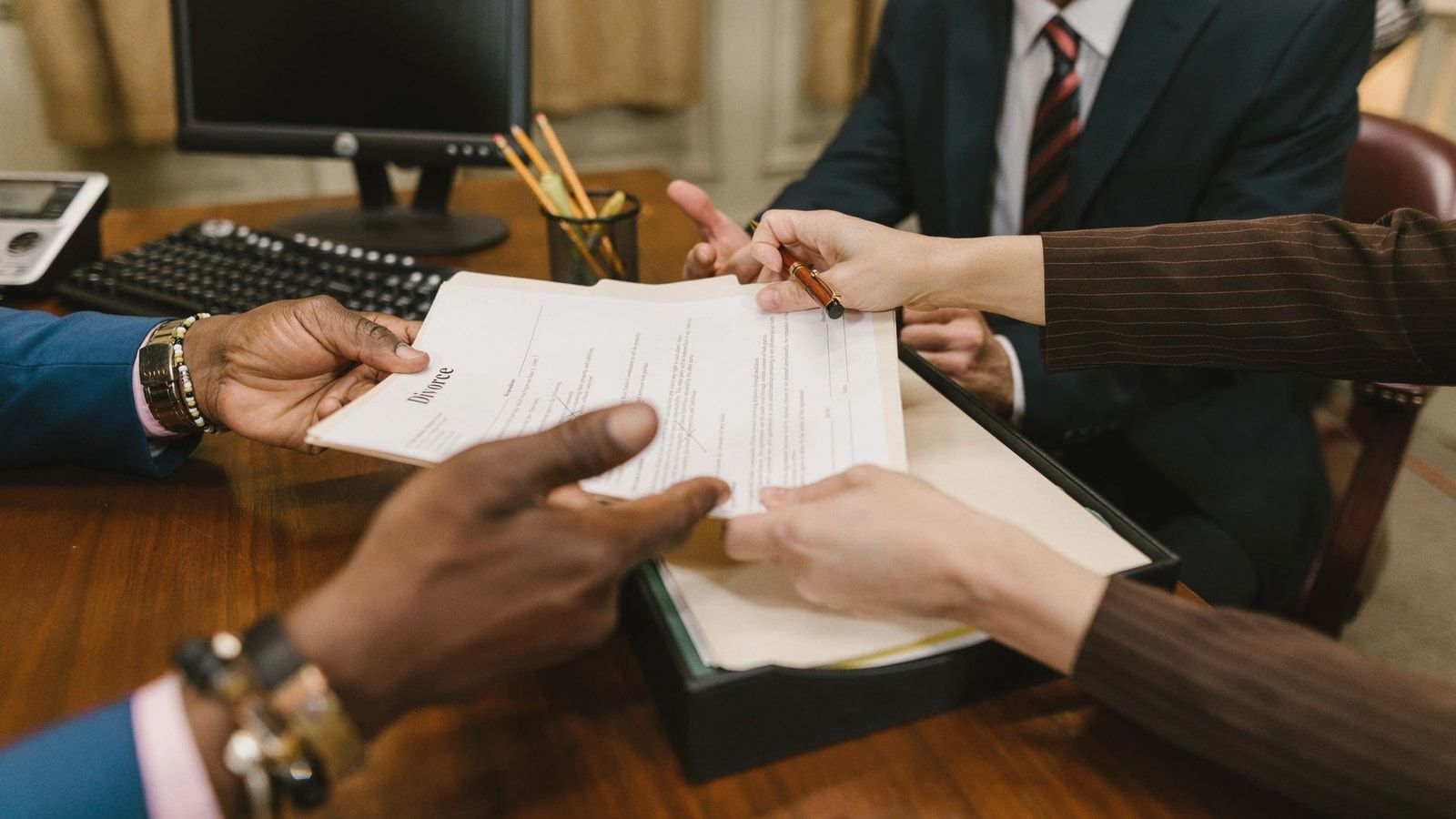 Professional meeting with individuals signing legal documents in an office setting.