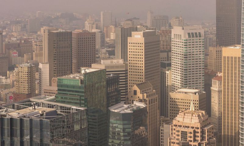 Aerial view of San Francisco skyscrapers enveloped in fog, highlighting the city's urban architecture.