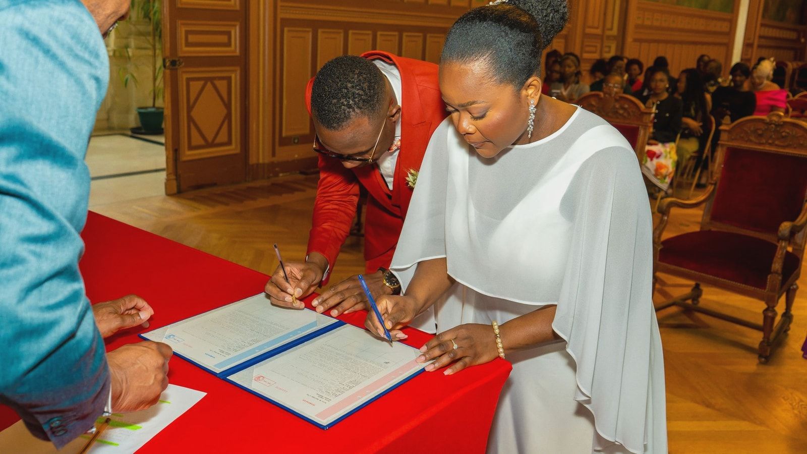 Bride and groom signing marriage documents with elegant decor
