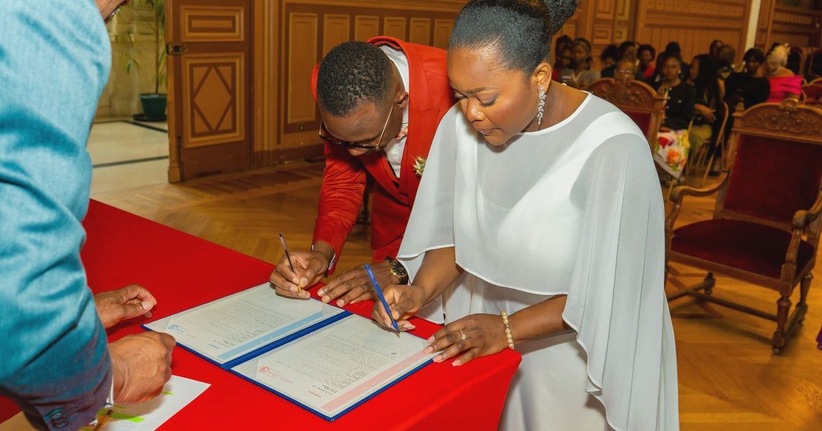 Bride and groom signing marriage documents with elegant decor