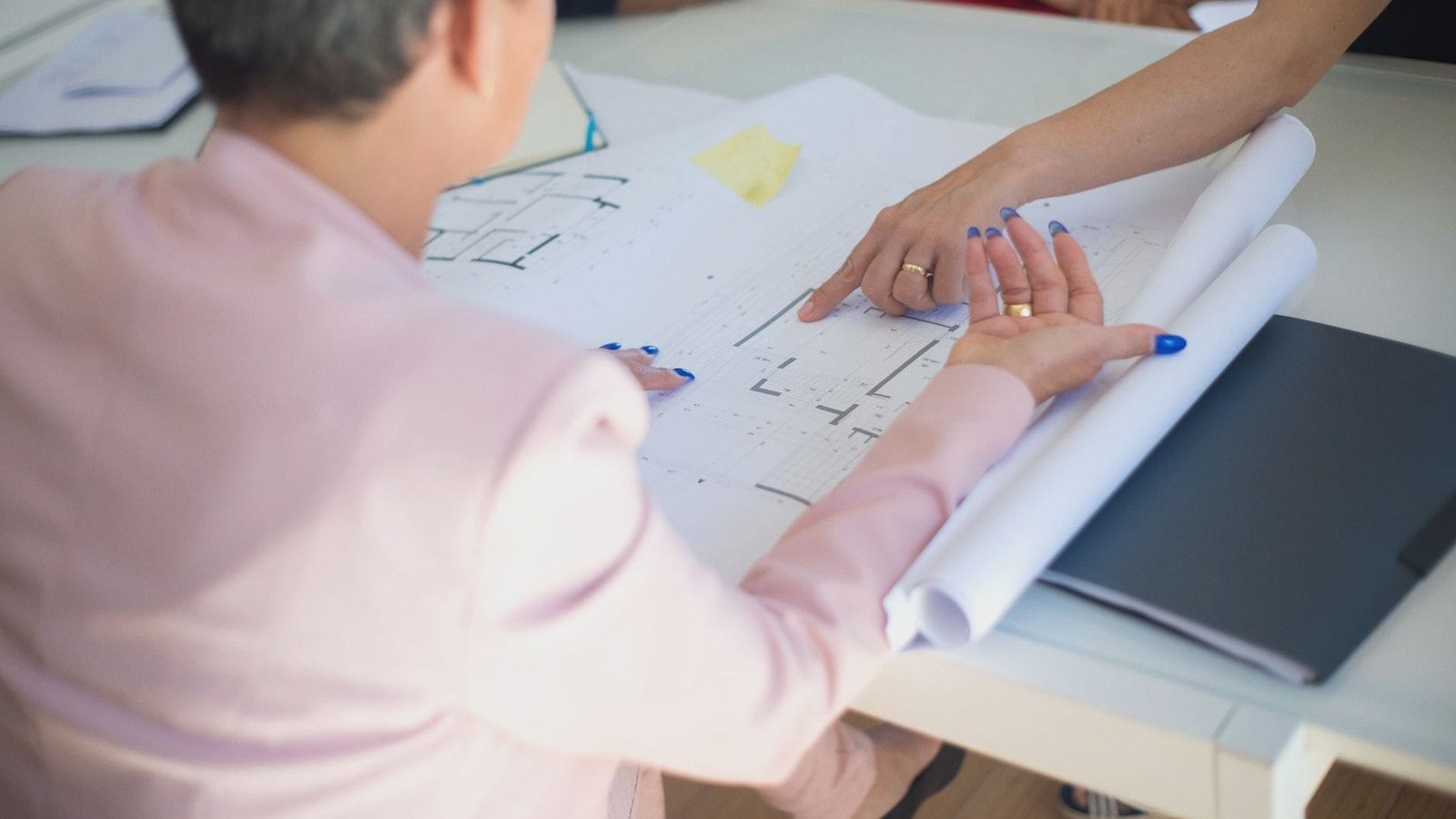 Group discussing architectural floor plans in an office setting.