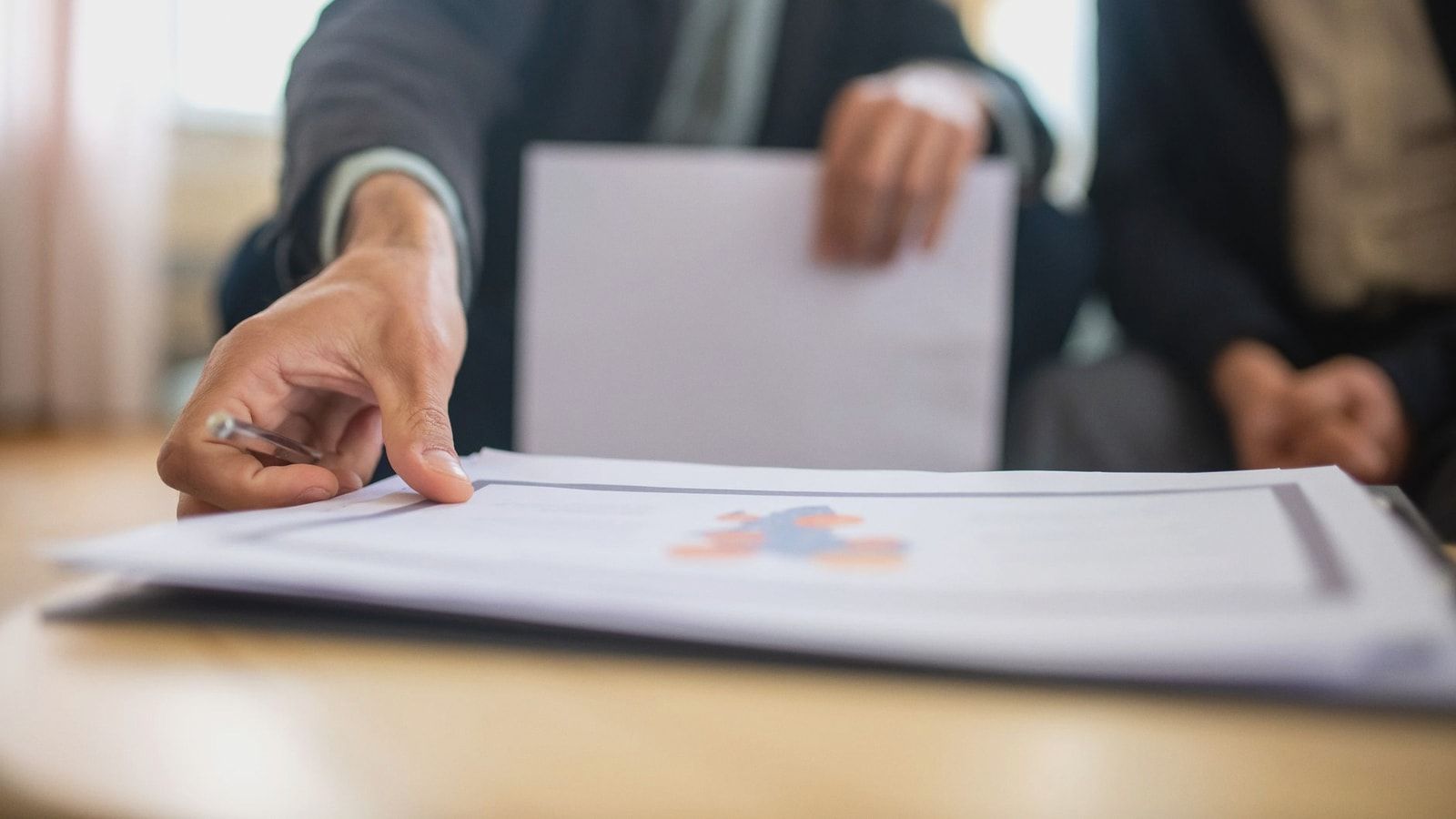 Close-up of a businessman reviewing important documents at a desk in an office setting.