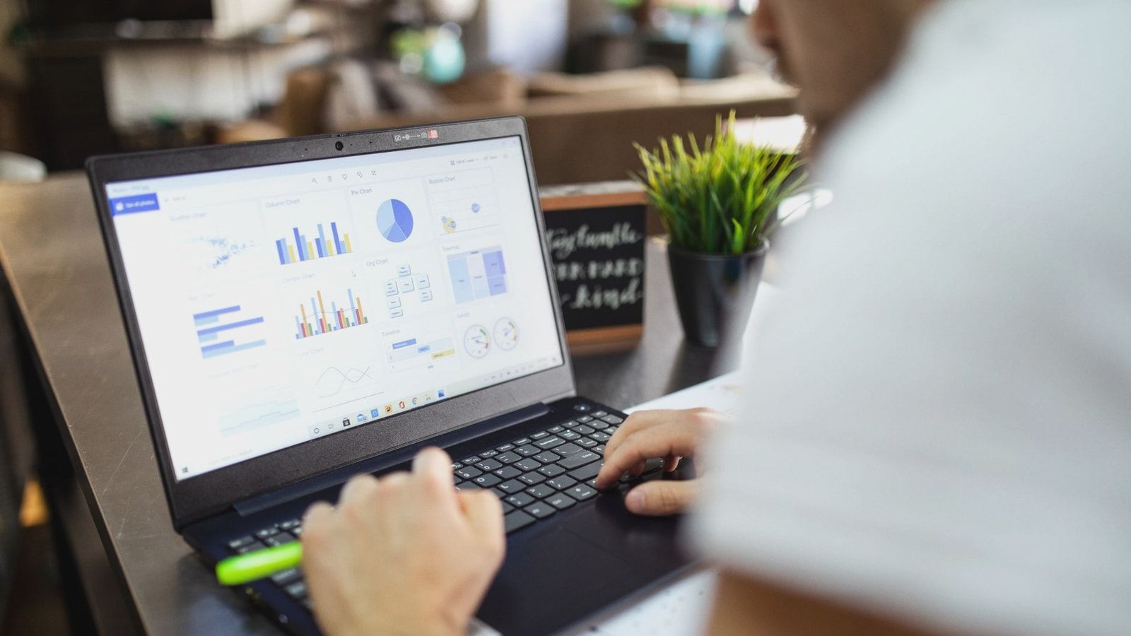 Focused business analysis with charts and graphs on a laptop in a modern office setting.