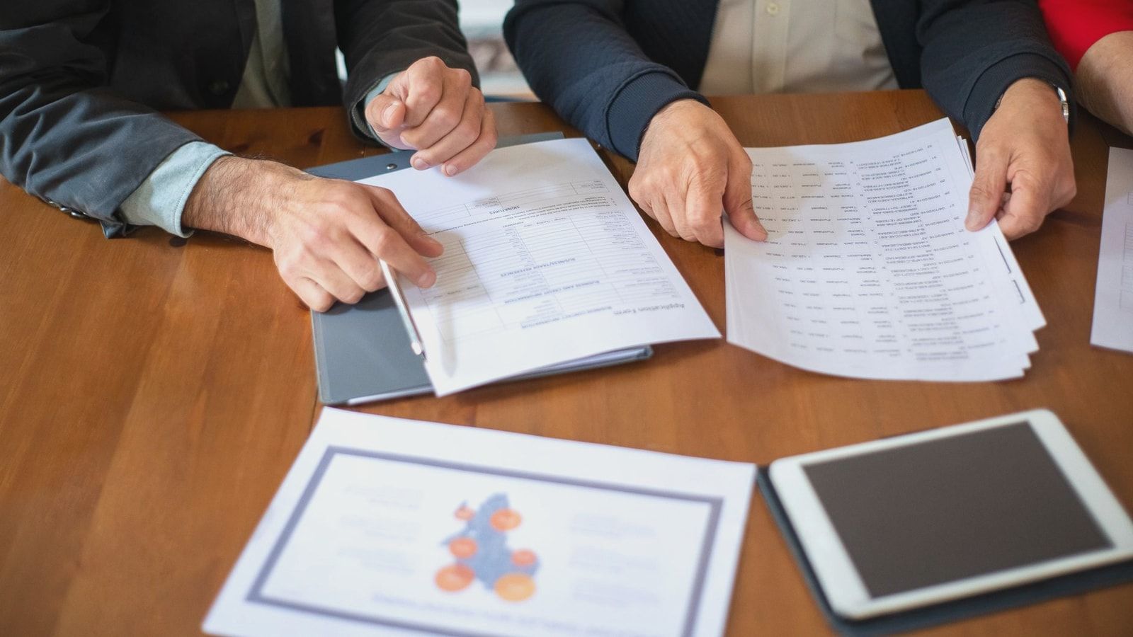 Two business professionals discussing and reviewing documents during a meeting.