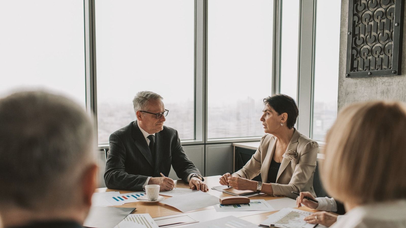 Business professionals engaged in a strategic meeting in a modern office setting with natural light.