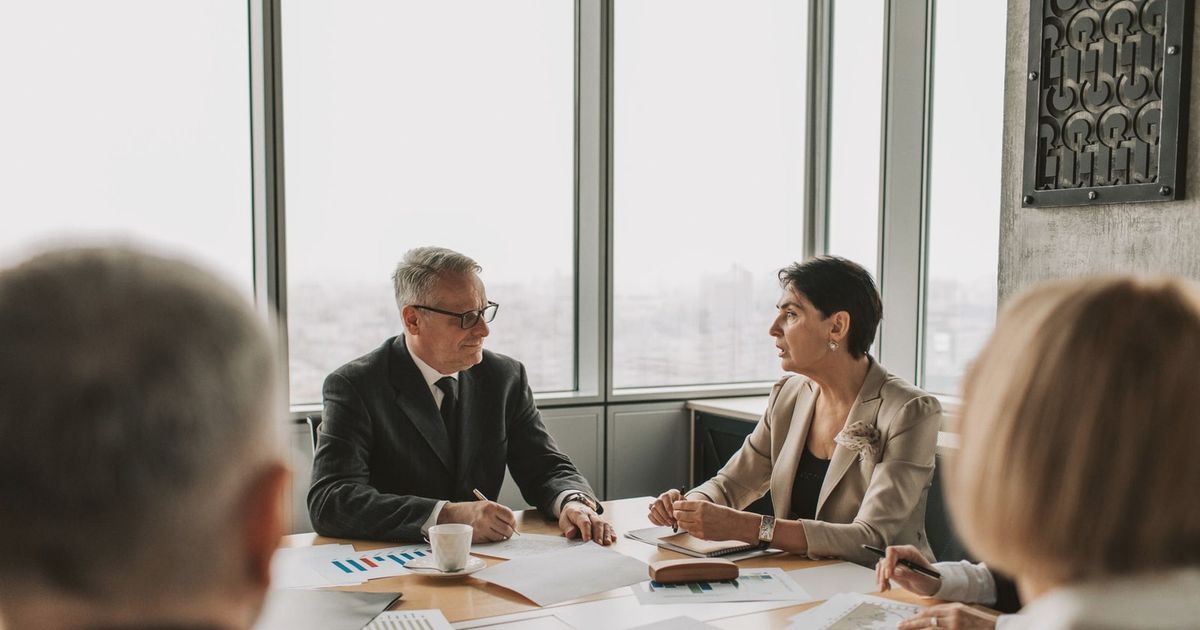 Business professionals engaged in a strategic meeting in a modern office setting with natural light.