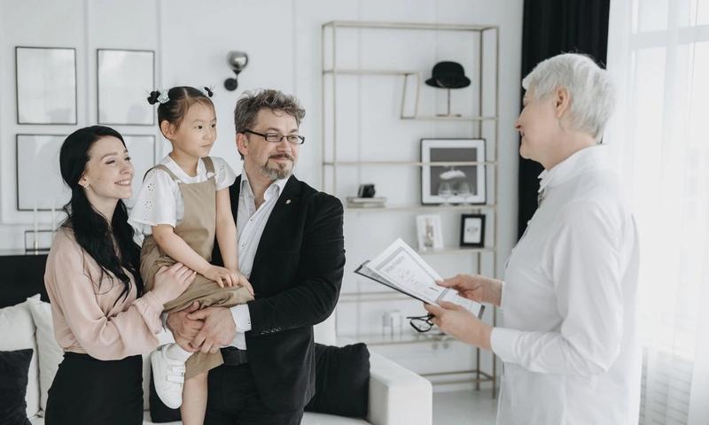 A joyful adoptive family meeting with a social worker indoors.
