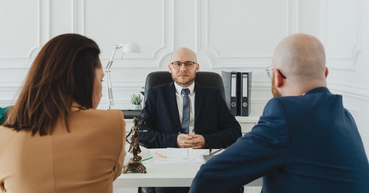 Lawyer meeting with clients in a formal office setting for legal consultation.