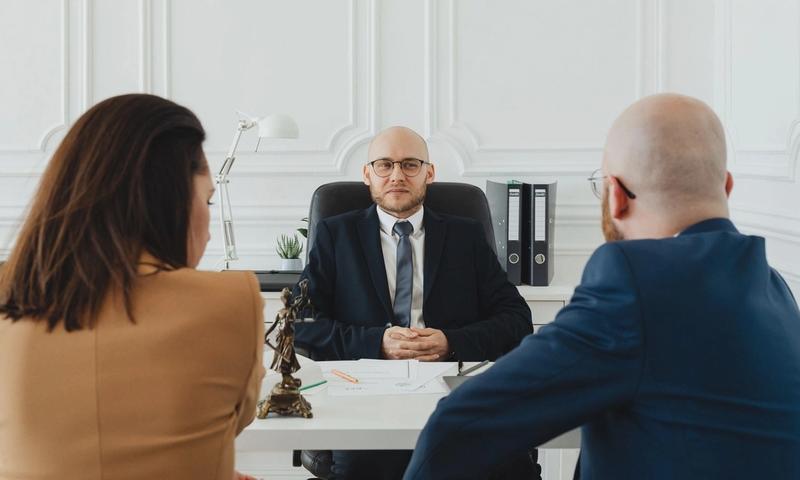 Lawyer meeting with clients in a formal office setting for legal consultation.