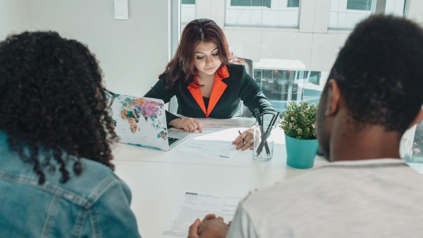 A couple discussing legal documents with a lawyer in a modern office environment.