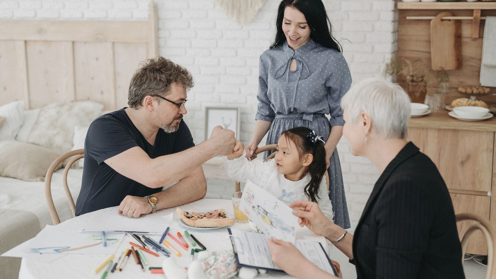 Child with foster parents and a social worker discussing adoption at home.