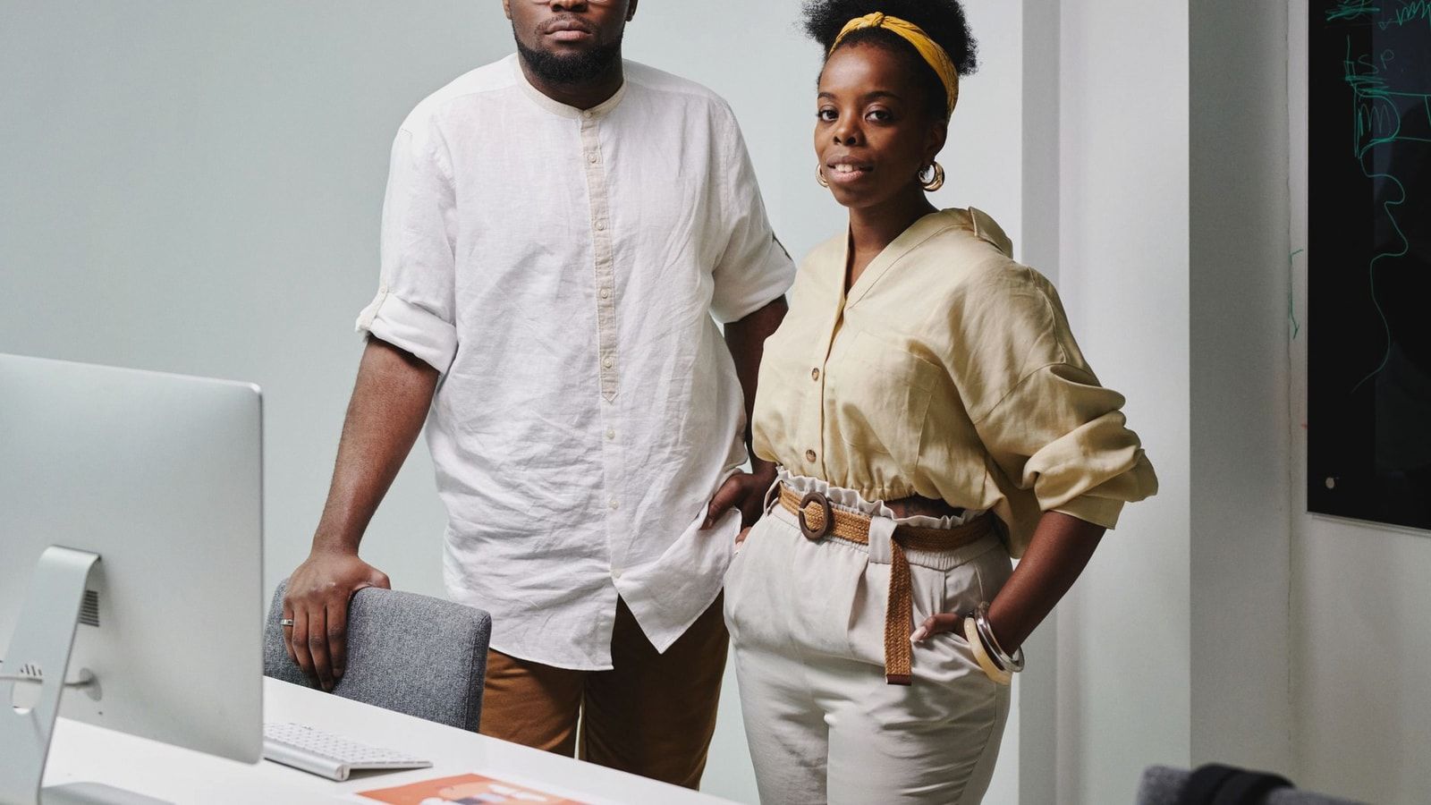 Portrait of a confident African American man and woman standing in an office setting.