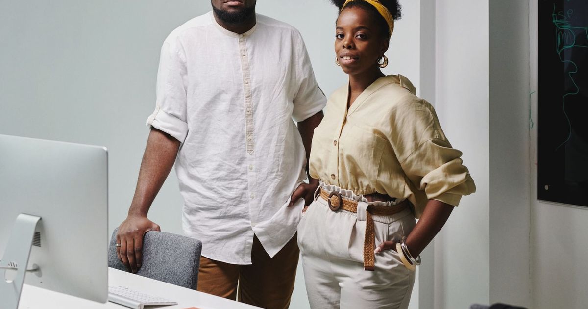 Portrait of a confident African American man and woman standing in an office setting.