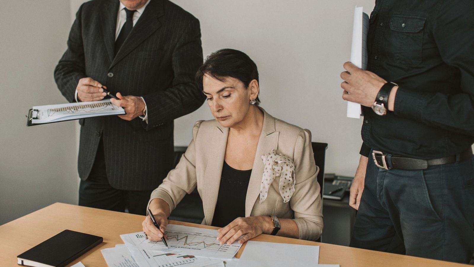 Business professionals collaborating on financial documents in an office setting.