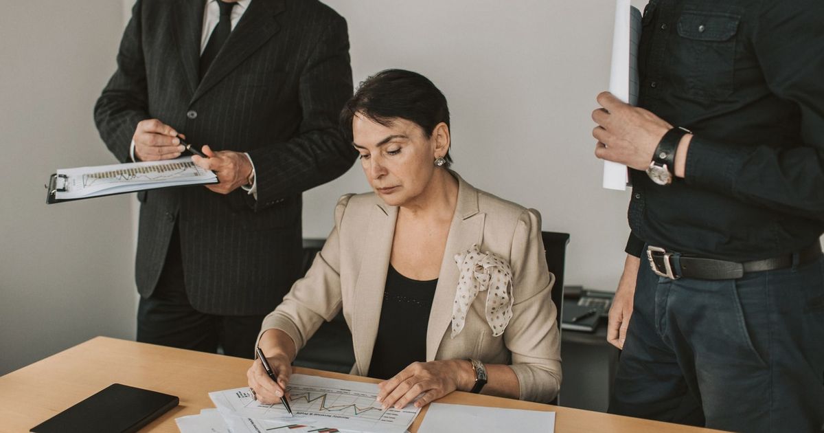 Business professionals collaborating on financial documents in an office setting.