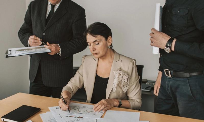 Business professionals collaborating on financial documents in an office setting.