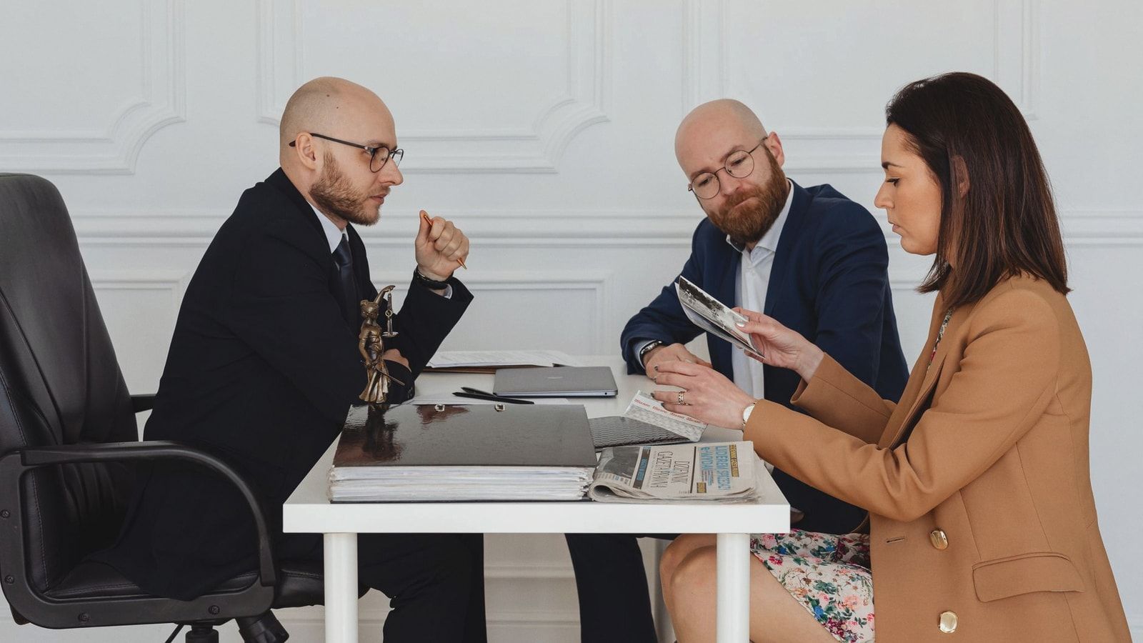 A group of professionals discussing and reviewing documents in an office setting.