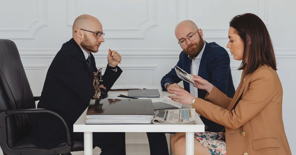 A group of professionals discussing and reviewing documents in an office setting.
