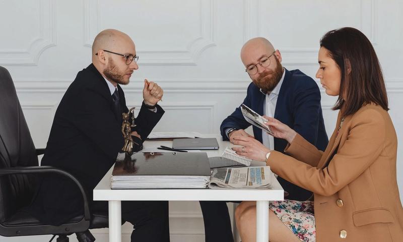 A group of professionals discussing and reviewing documents in an office setting.