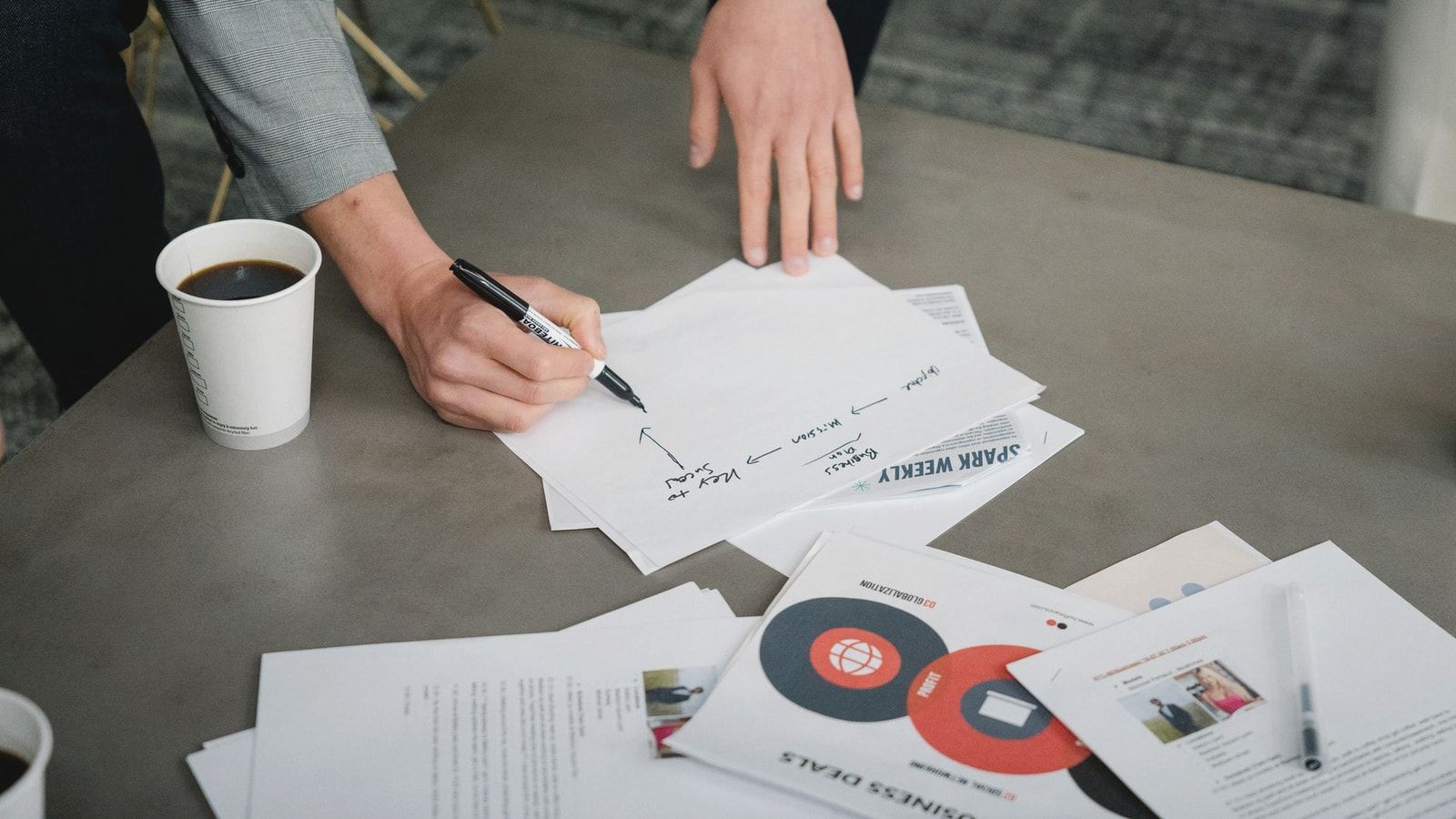 Team members reviewing and annotating business documents during a meeting.