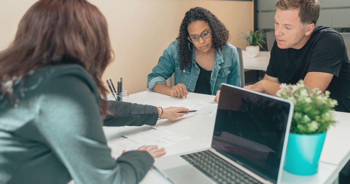 Couple meeting with advisor for adoption process in a modern office setting.