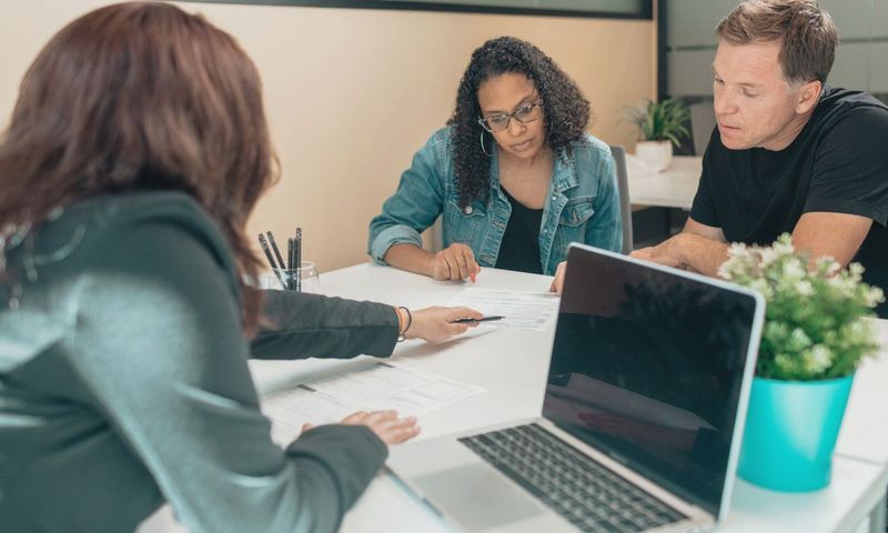 Couple meeting with advisor for adoption process in a modern office setting.